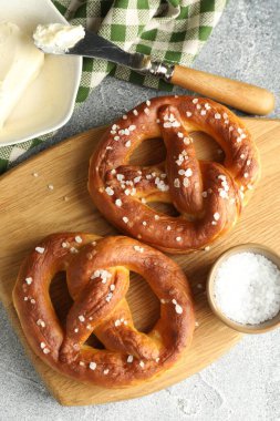 Tuz ve tereyağlı lezzetli krakerler açık gri masada, düz yerde.
