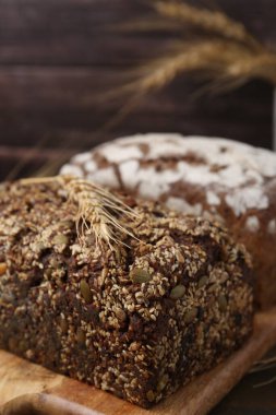 Taze pişmiş somun ekmek ve çiviler kahverengi arka planda, yakın plan