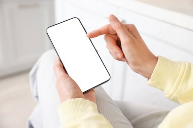 Evde modern akıllı telefon kullanan bir kadın, yakın plan.