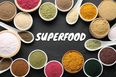 Süper yemek. Kâse ve kaşıklardaki farklı pudralar siyah masada, düz yerde.