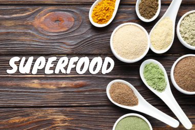 Süper yemek. Tahta masanın üzerinde farklı pudralar ve kaşıklar var.