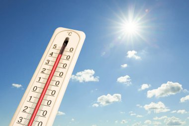 Güneşli bir günde mavi gökyüzüne karşı termometrede son derece yüksek sıcaklık. Yaz havası