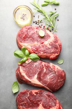 Çiğ et parçaları ve baharatlar gri masada, düz yatıyordu.