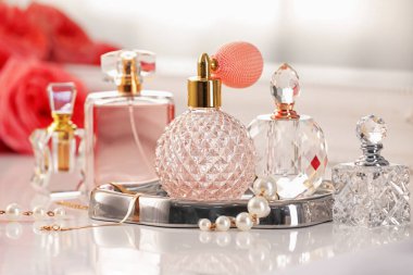 İçerideki tuvalet masasında farklı parfüm ve aksesuar şişeleri, yakın plan.