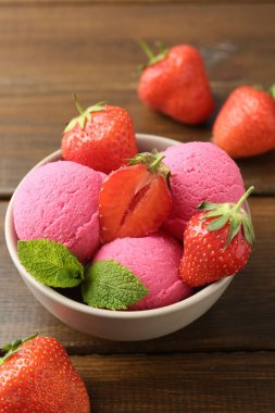 Çilekli şerbet ve ahşap masada servis edilen nane şekeri, yakın plan.