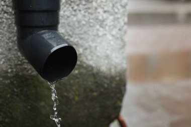 Kanalizasyon borusundan su damlıyor, yakın plan. Metin için boşluk