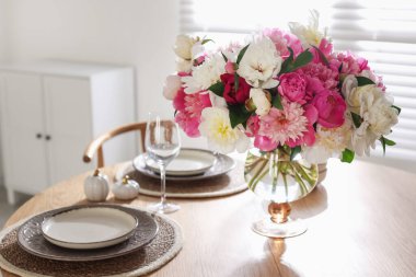 Yemek odasında şakayık demeti olan güzel bir masa, yakın plan.