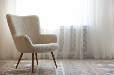 Pencerenin yanındaki rahat beyaz koltuk, metin için boşluk