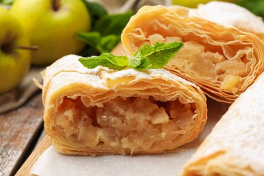 Masada pudra şekeri, nane ve meyveli elmalı turtalar, yakın plan.