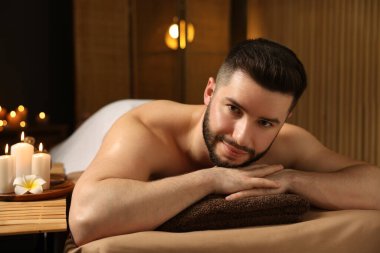 Güzellik salonunda masaj masasında yatan yakışıklı adam.