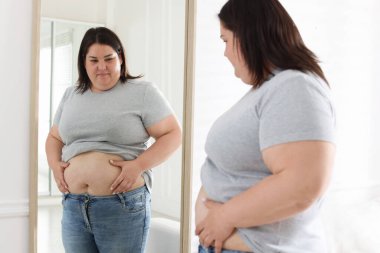 İçeride aynanın yanında göbeği aşırı yağlı bir kadın var. Aşırı kilolu