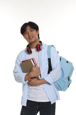 Beyaz arka planda kulaklık, kitap ve sırt çantası olan öğrenci.