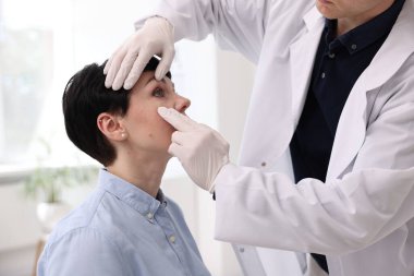 Klinikte hastanın vizyonunu inceleyen profesyonel göz doktoru.