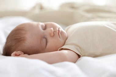 Yeni doğmuş şirin bebek evde yatakta uyuyor.