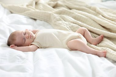 Yeni doğmuş şirin bebek evde yatakta uyuyor.