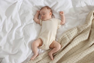 Yeni doğmuş şirin bir bebek. Yatakta uyuyor. Üst tarafta.