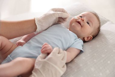 Klinikteki masada bebeği muayene eden çocuk doktoru, yakın plan.