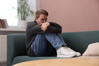 Evdeki koltukta paranoyadan muzdarip bir adam