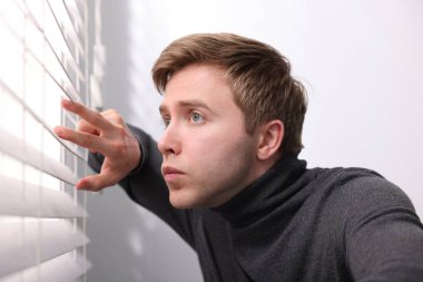 Paranoya işte. Endişeli adam pencereden içeri bakıyor.