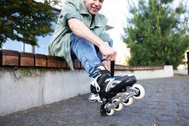 Dışarıda paten kayan mutlu genç bir adam, seçici bir odak noktası.