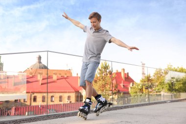 Mutlu adam şehir caddesinde paten kayıyor.