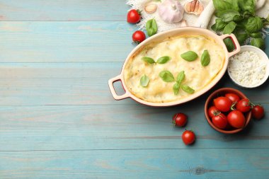 Lezzetli vejetaryen lazanya ve açık mavi ahşap masa üzerindeki malzemeler. Metin için boşluk