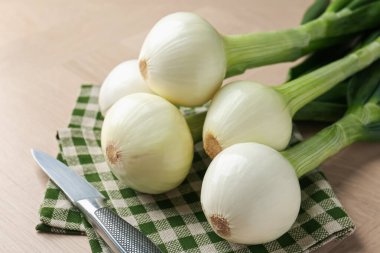 Taze taze soğan ve bıçak ahşap masada, yakın plan.