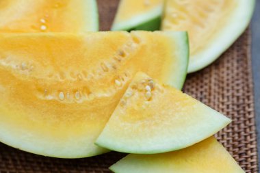 Hasır masada olgun sarı karpuz parçaları, yakın plan.