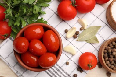 Lezzetli domatesler kasede ve malzemeler masada, düzdü.