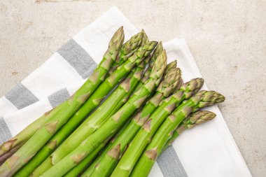 Açık gri masada taze çiğ kuşkonmaz.
