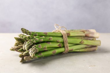 Açık gri masada taze çiğ kuşkonmaz, yakın plan.