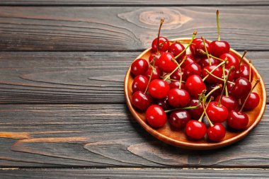 Siyah ahşap masada taze kirazlar, yakın plan. Metin için boşluk