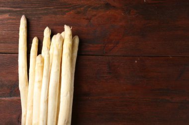 Ahşap masada bir sürü çiğ kuşkonmaz mızrağı var. Metin için boşluk