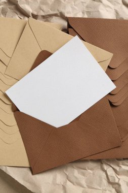 Boş davetiye kartı, zarflar ve parşömen kağıdı masanın üstünde. Tasarım için boşluk
