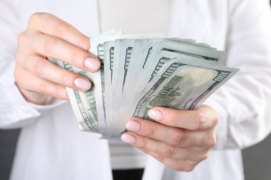 Dolar banknotları sayan bir kadının yakın görüntüsü