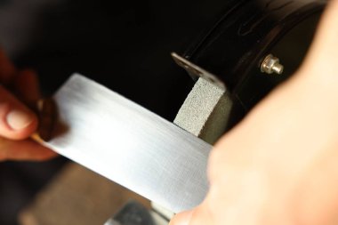 Bıçak keskinleştiren adam içeride, yakın plan.