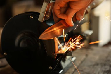 Bıçak keskinleştiren adam içeride, yakın plan.