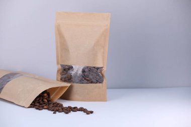 Açık gri arka planda kahve çekirdekli fermuar stand-up torbaları. Tasarım için model