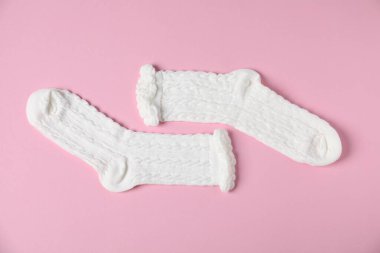 Pembe arka planda bir çift rahat beyaz çorap, üst manzara