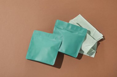 Kahverengi arka planda fermuar stand-up torbaları, düz yatış. Tasarım için model