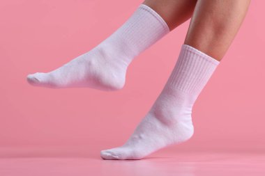 Pembe arka planda beyaz çoraplı kadın, yakın plan.