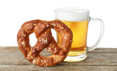 Lezzetli kraker ve bir bardak bira beyaz arka plana karşı ahşap masada.