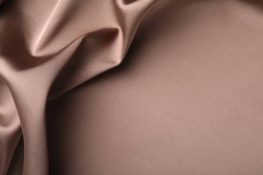 Arkaplan olarak buruşuk açık kahverengi ipek kumaş, yakın plan