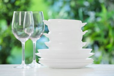 Bulanık yeşil arka planda beyaz masada farklı temiz tabaklar