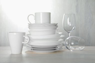 İçerideki açık ahşap masada farklı temiz bulaşık takımı.