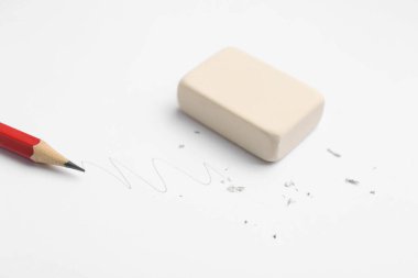 Beyaz arkaplanda kalem, silgi, karalama ve kırıntılar, yakın plan