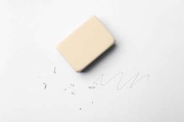 Beyaz arkaplanda silgi, karalama ve artıklar, üst görünüm