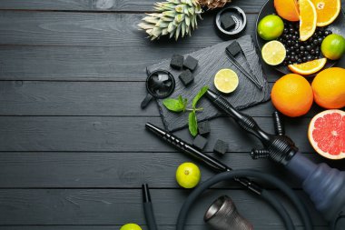 Nargile, kömür ve taze meyveler siyah ahşap masada, düz yerde. Metin için boşluk