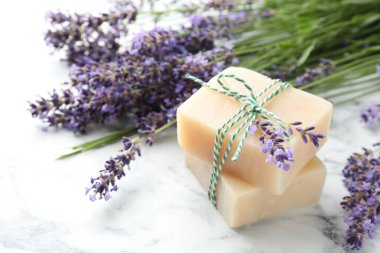 Sabun çubukları ve lavanta çiçekleri beyaz mermer masada, yakın plan.