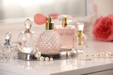 İçerideki tuvalet masasında farklı parfüm ve aksesuar şişeleri, yakın plan.